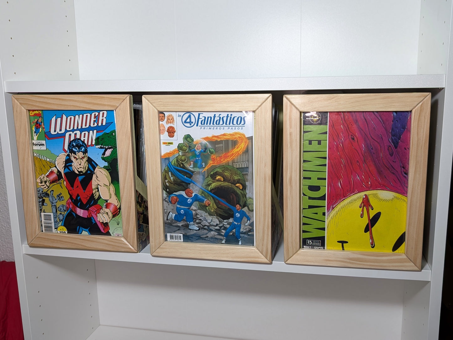 Tres cajas abiertas para grapas en una balda de IKEA Billy, con portadas visibles en el frontal.