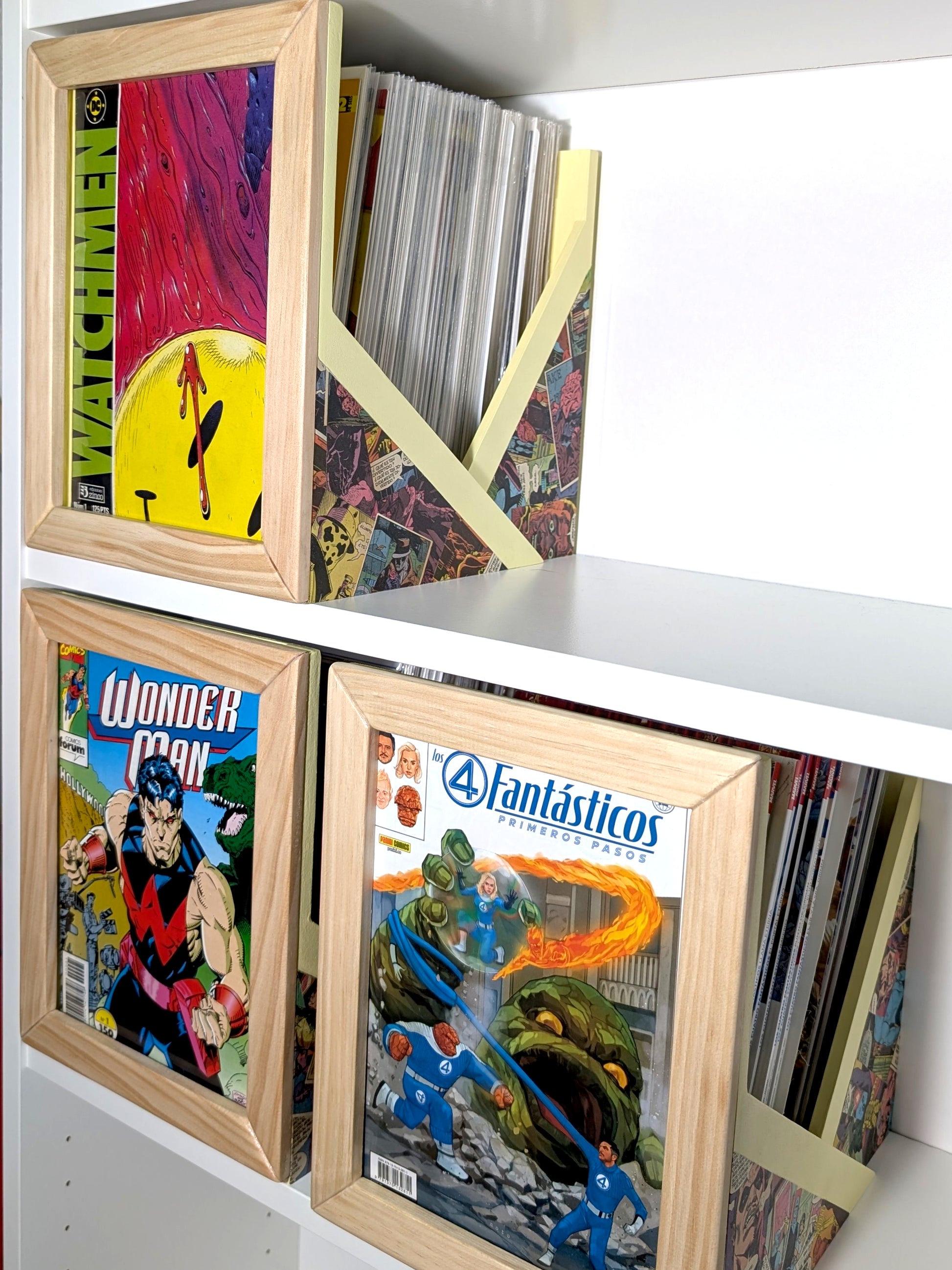 Tres cajas abiertas de madera para grapas en estantería, con una grapa expuesta en cada frontal.